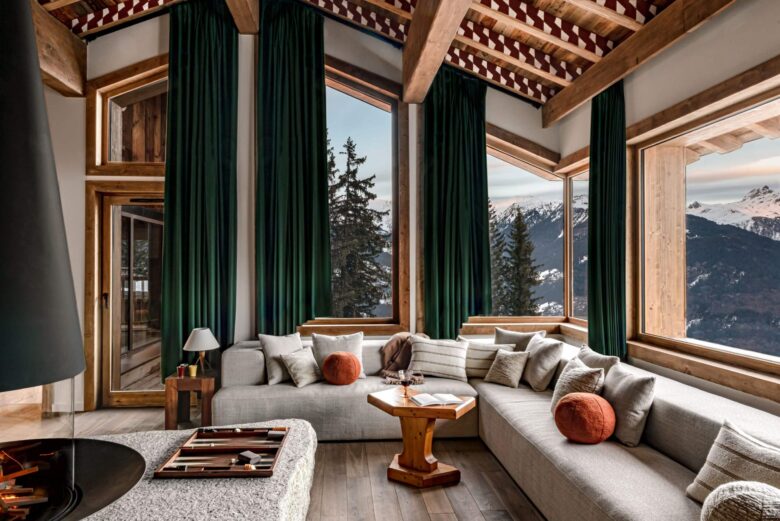 Tall ceilings and windows with green curtains in the Iconic House 1550 living room. Part of the luxury chalet club collection
